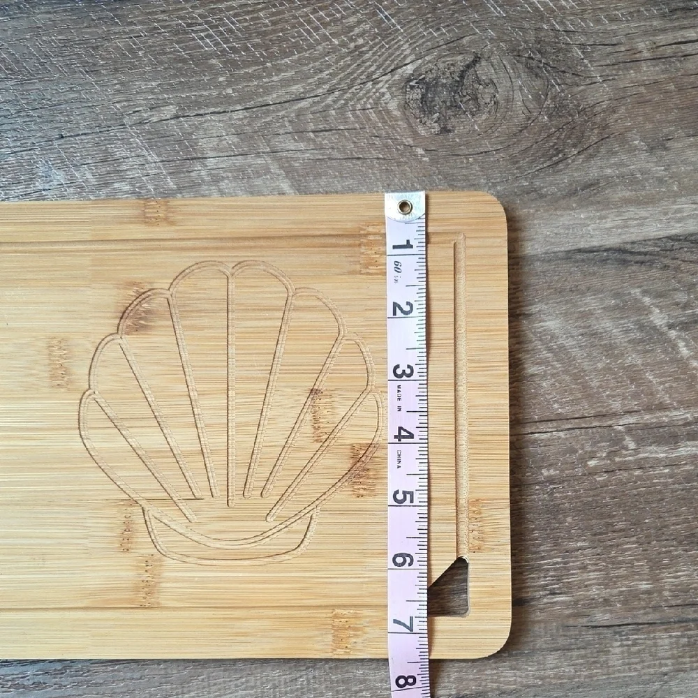New Bamboo Cutting Board with Shell Design Carved In It